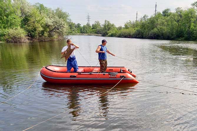 спасатели на резиновой лодке ищут рыбака