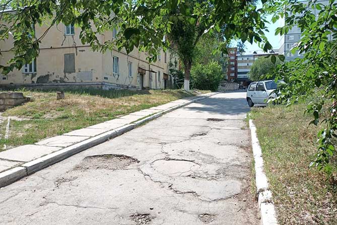 выбоины на дороге возле дома на Мурысева 83а