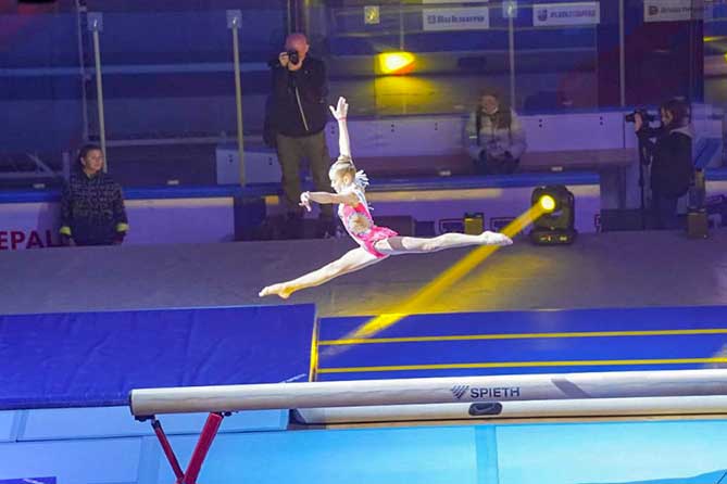 юная гимнастка на спортивном бревне