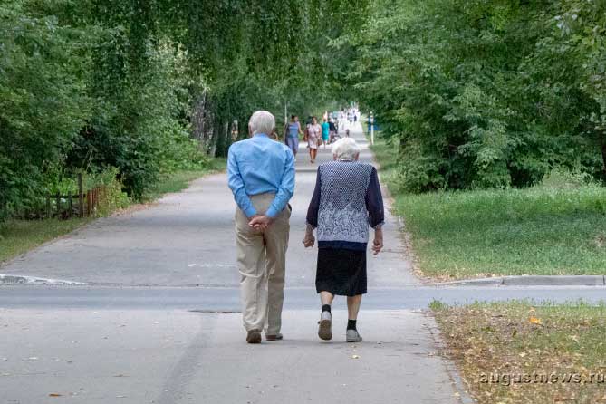 пожилые мужчина и женщина идут по улице
