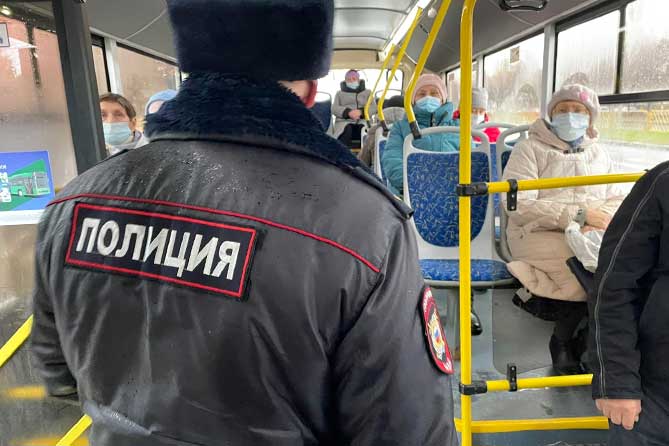 сотрудник полиции проверяет маски у пассажиров