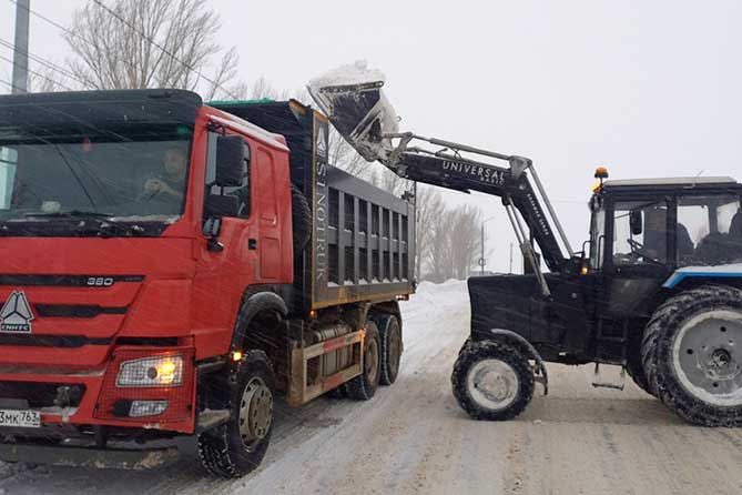 погрузка снега в грузовик на вывоз