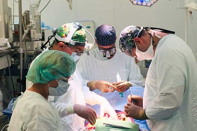 хирурги выполняют операцию на сердце