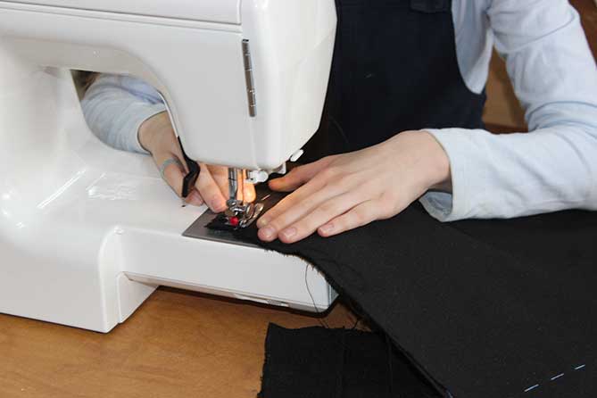 ученица шьет на швейной машинке
