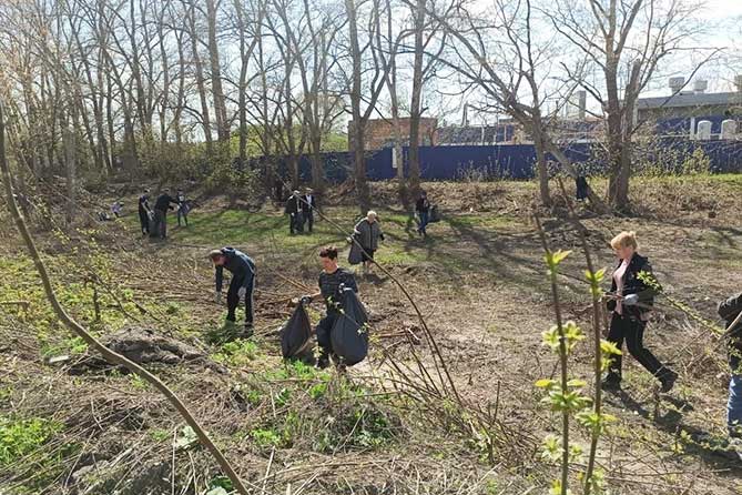 В Тольятти вынужденные переселенцы поучаствовали в уборке города люди убирают мусор вдоль Автозаводского шоссе