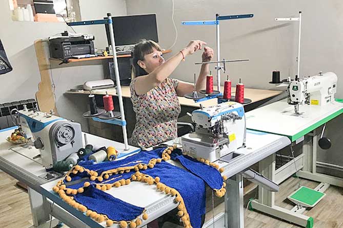 женщина шьет шторы на швейной машине