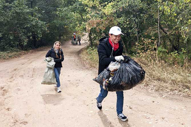 волонтеры несут мусор в мешках