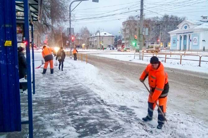 дорожные службы чистят снег на остановке по улице Карла Маркса