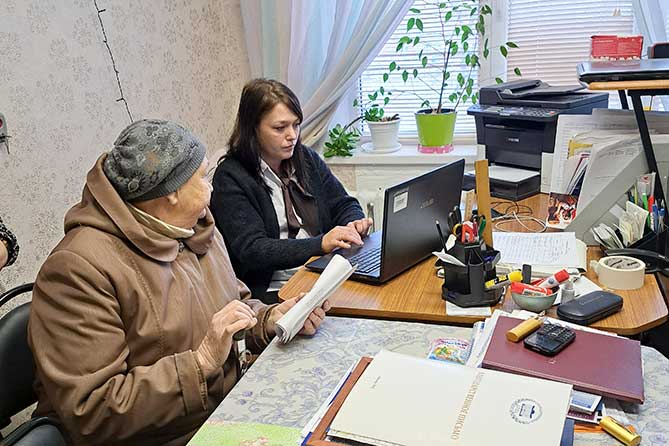 сотрудник МФЦ помогает пенсионерке в Ресурсном центре