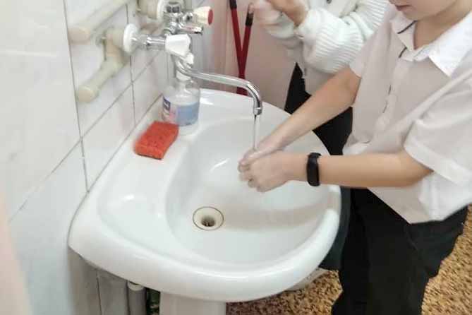 школьник моет руки