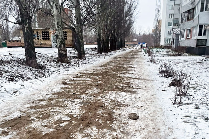 песок посыпан на тротуаре зимой
