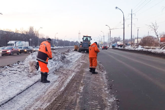 рабочие убирают прибордюрную наледь на дороге