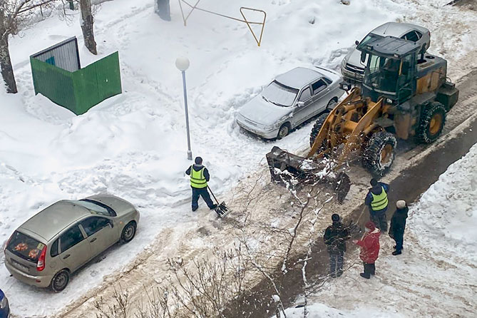 трактор убирает снег во дворе