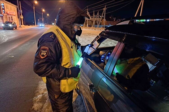 сотрудник ГИБДД проверяет документы водителя