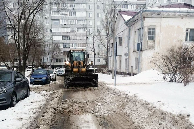 трактор чистит снег во дворе