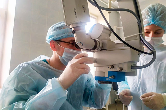 врач-офтальмолог проводит операцию ребенку
