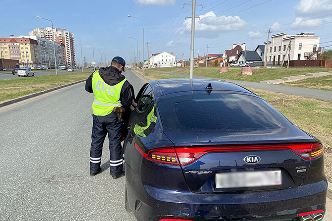 сотрудник ГИБДД проверяет документы водителя