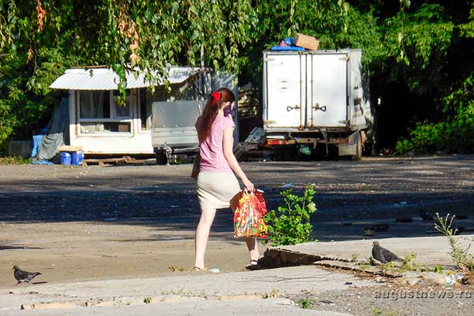 девушка с телефоном идет по городу