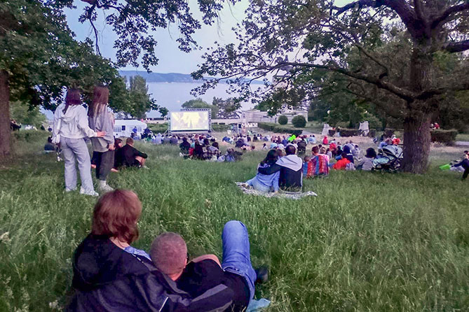 жители на кинопоказе под открытым небом