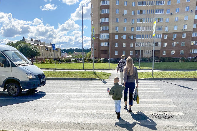 женщина с ребенком переходит по пешеходному переходу