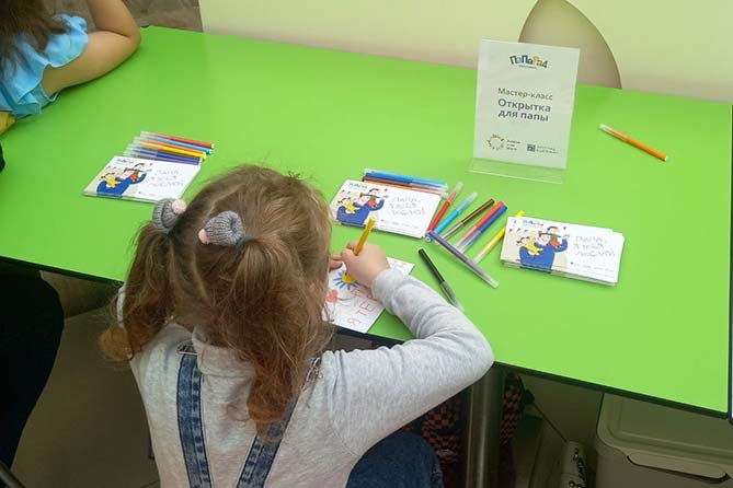 девочка рисует открытку для отца