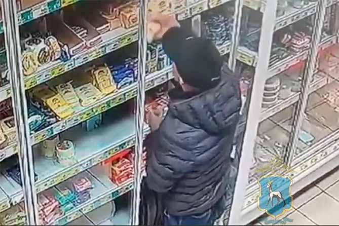 мужчина берет масло с прилавка