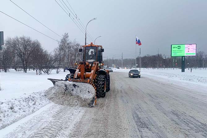 трактор чистит снег на улице спортивной
