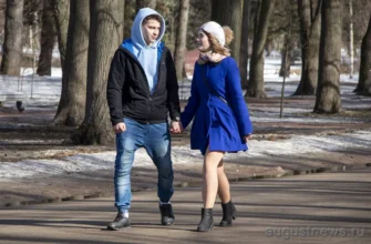 девушка с парнем идут по парку за руку