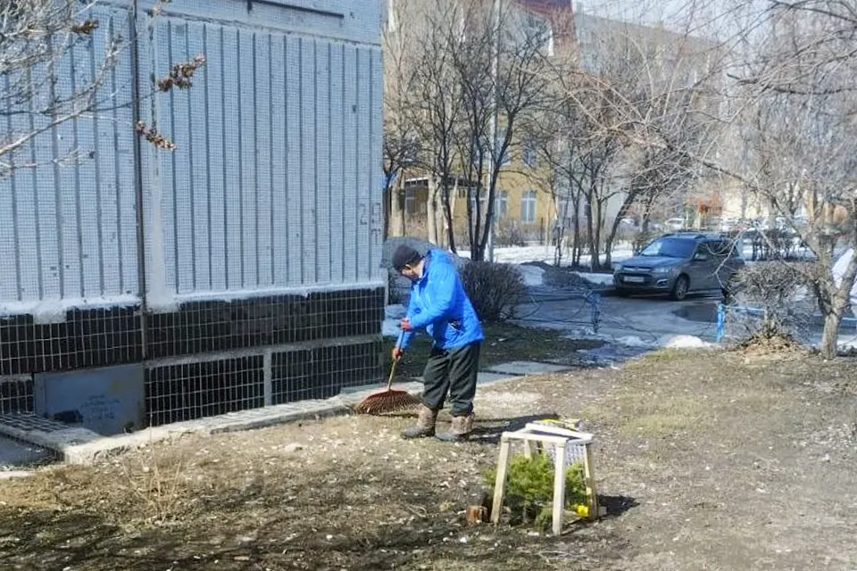 дворник убирает дворовую территорию от мусора
