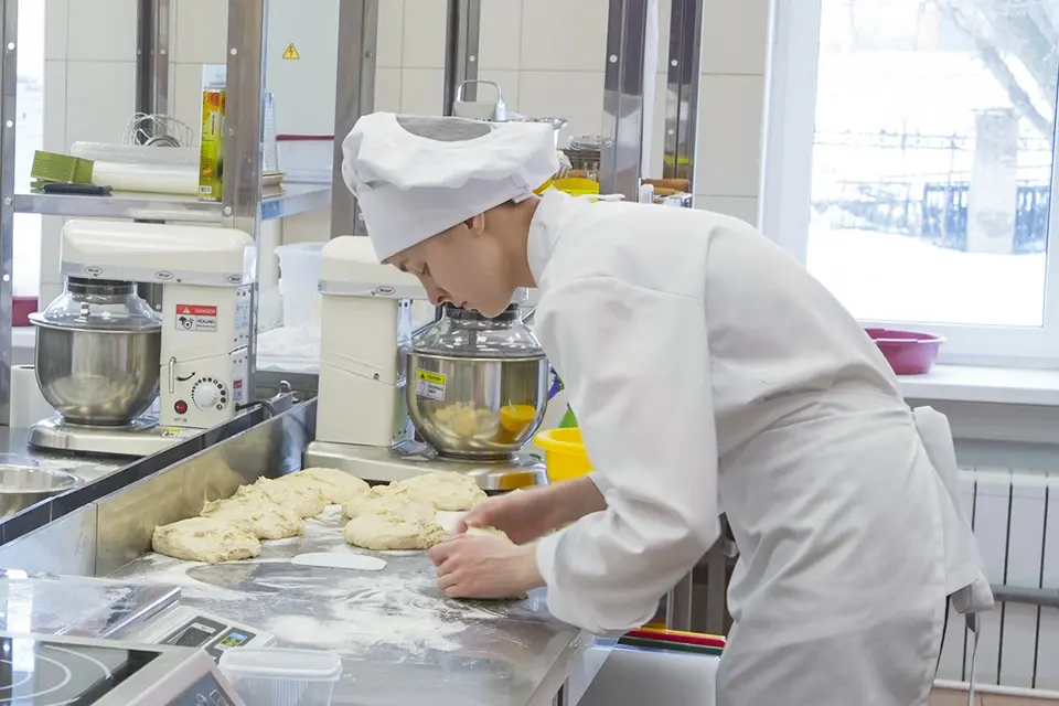 повар за работой на кухне булки