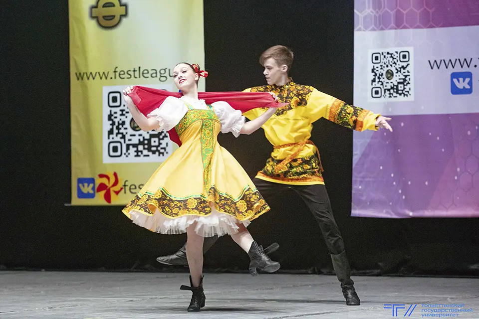 парень с девушкой танцуют в русских народных костюмах