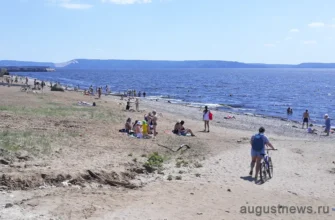 люди загорают на пляже набережной