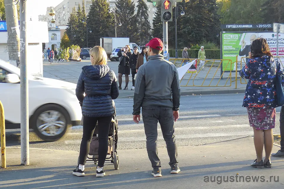 молодая пара с ребенком переходит дорогу