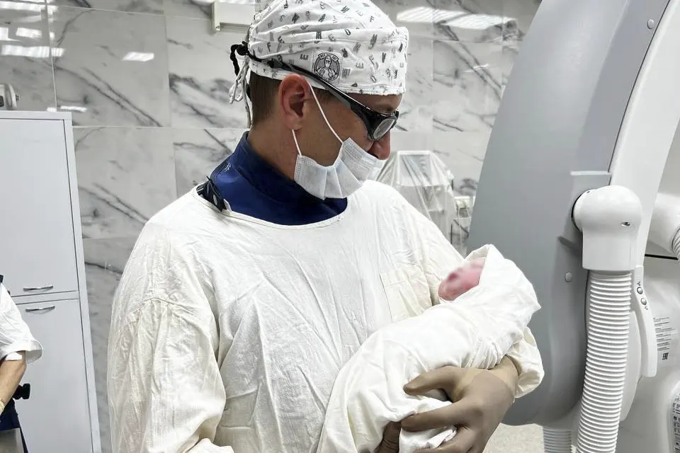 врач с новорожденным на руках