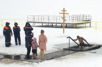 мужчина совершает обряд омовения в купели