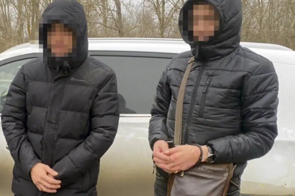 две мужчин в темных куртках с капюшоном