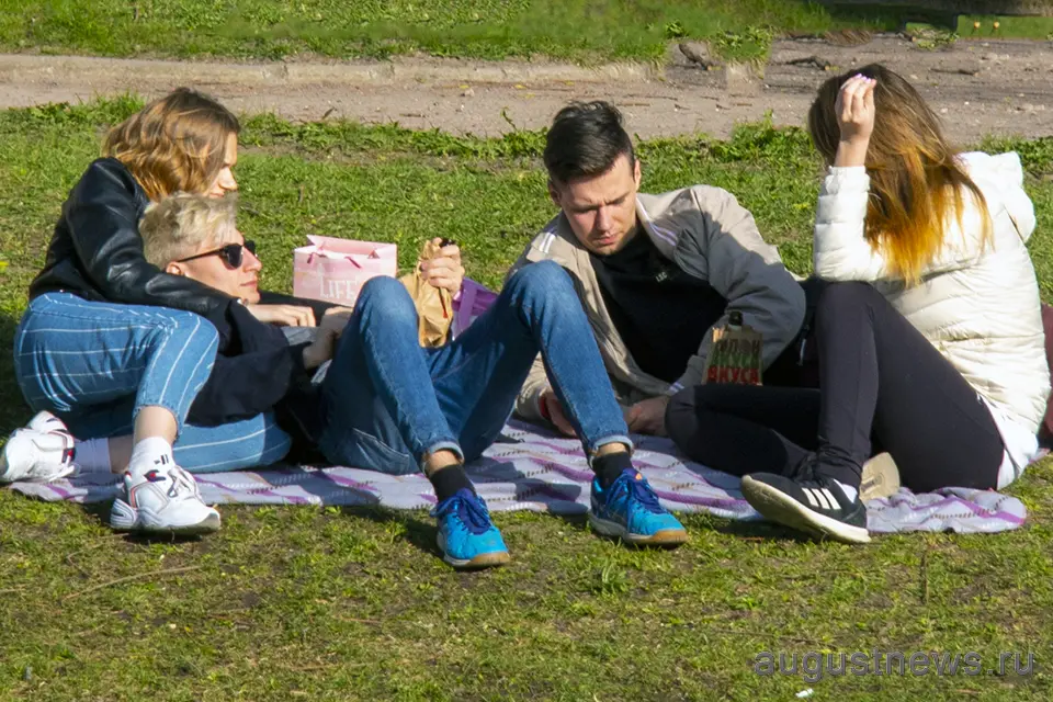 молодые люди отдыхают в парке на траве