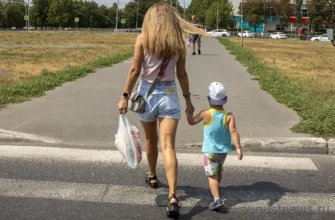 девушка ведет ребенка через пешеходный переход в Тольятти