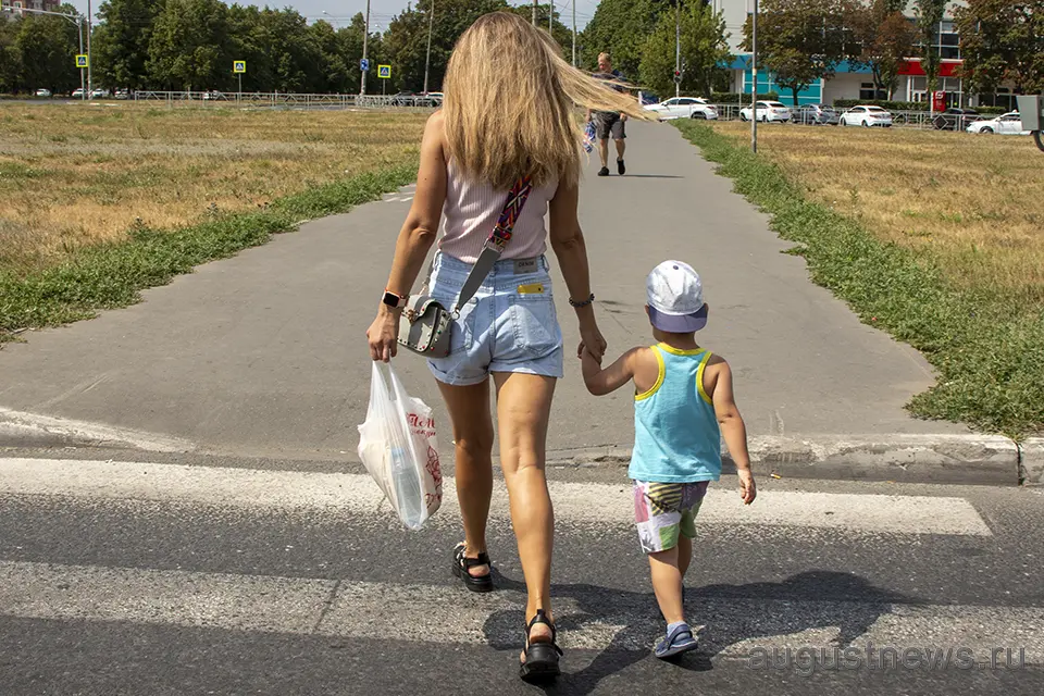 девушка ведет ребенка через пешеходный переход в Тольятти