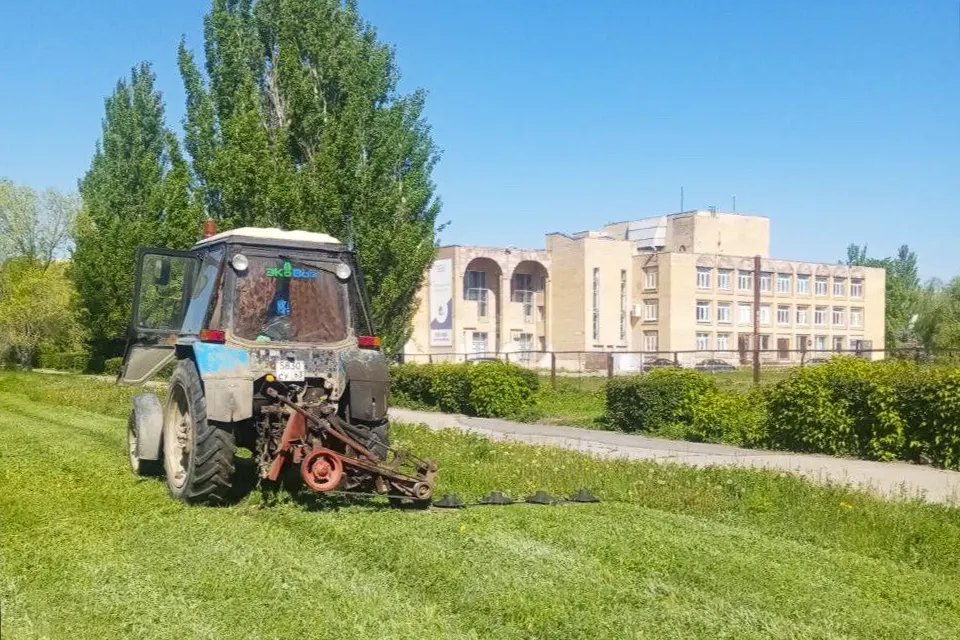 трактор косит траву