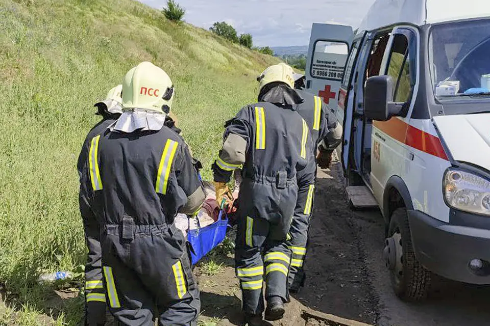 спасатели несут пострадавшего в скорую помощь