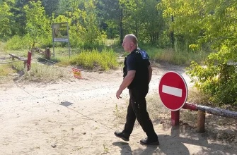 сотрудник ЧОП на въезде в лес