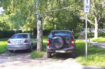 машины стоят на газоне во дворе