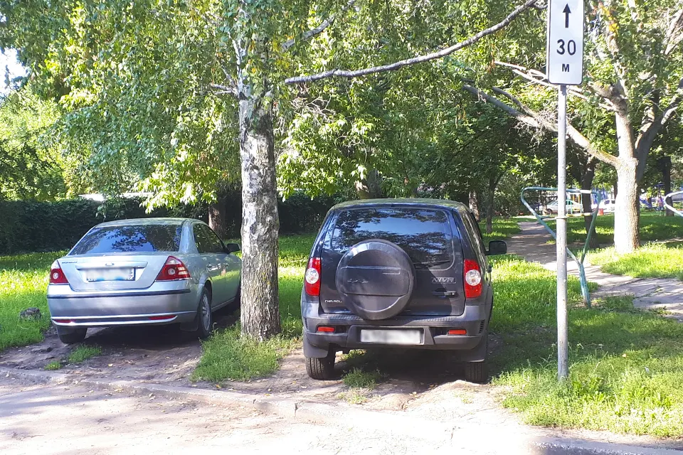 машины стоят на газоне во дворе