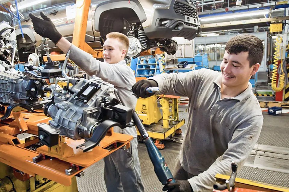 молодые веселые парни на конвейере автоваза