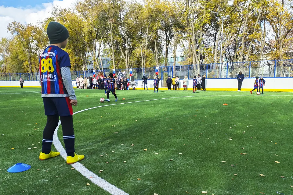 дети играют в футбол на спортплощадке