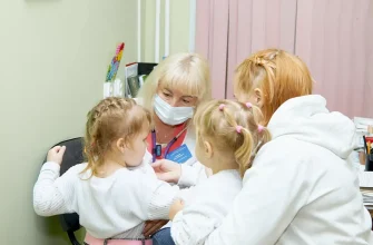 врач-педиатр осматривает ребенка