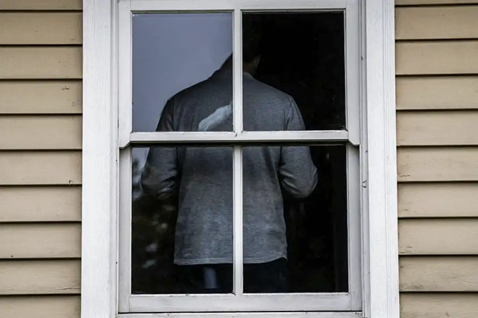 мужчина стоит около окна