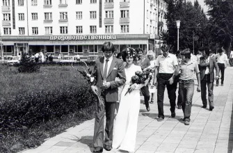 молодожены несут цветы к стеле