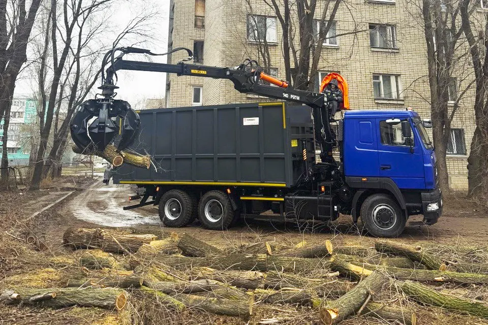 ломовоз загружает бревна
